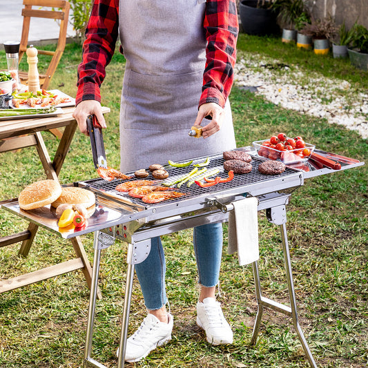 Barbacoa portátil plegable con mesa lateral cocinando carne y verduras al aire libre
