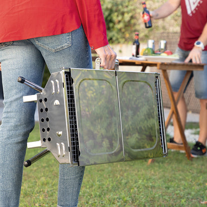 Barbacoa portátil plegable cerrada siendo transportada por su diseño compacto