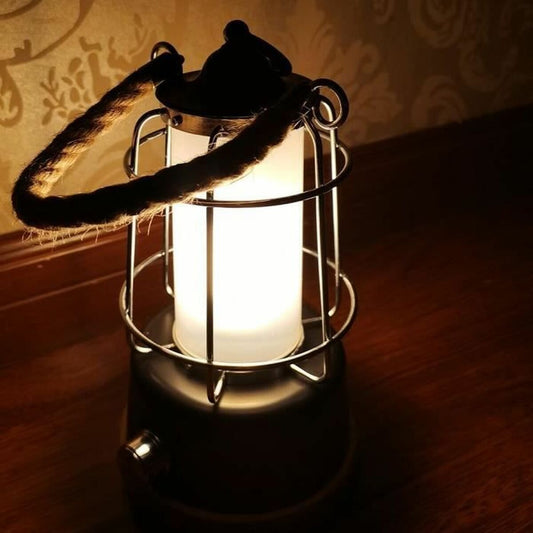 Lámpara de camping encendida con luz cálida creando ambiente acogedor en la oscuridad